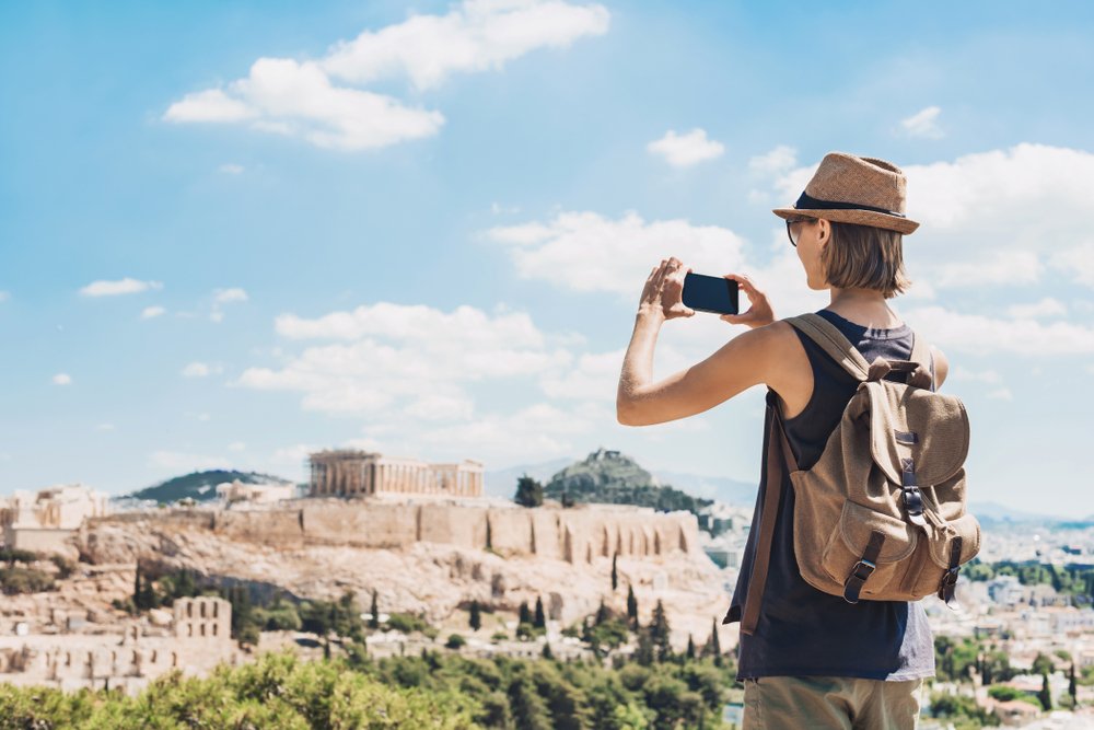 Young,Woman,Taking,Photographs,With,Smart,Phone,In,Athens,With